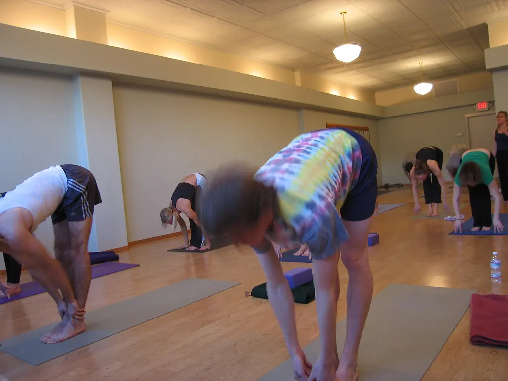 Clase de yoga en una sala de parqué